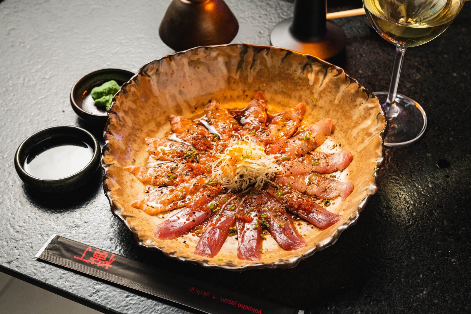 Prato compartilhado com peixe e finalização central no Yokocho Izakaya
