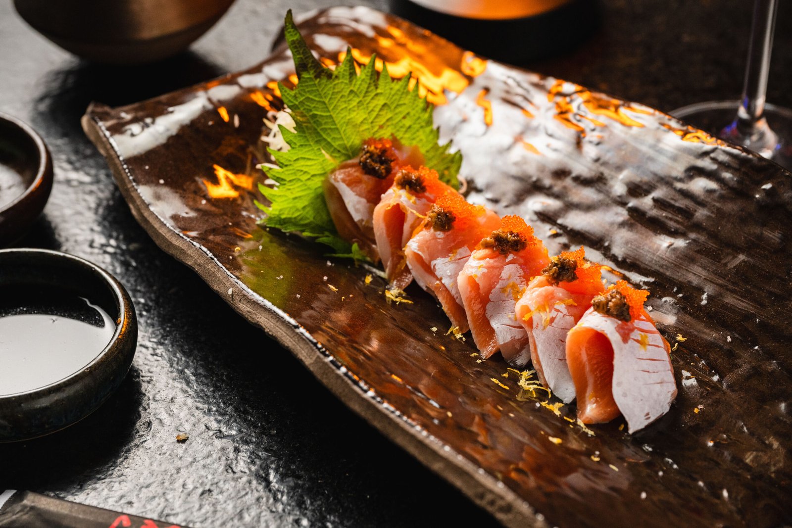 Fatias de peixe dispostas em sequência no Yokocho Izakaya