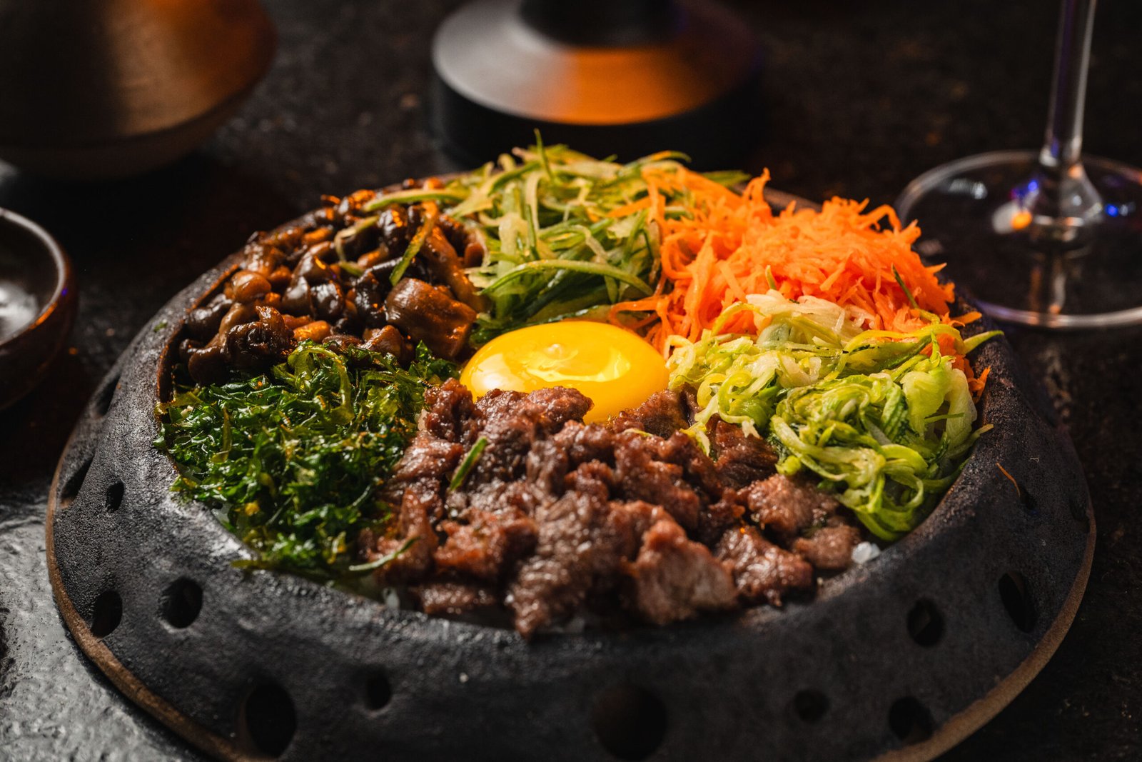 Prato oriental com carne, ovo e vegetais coloridos no Yokocho Izakaya