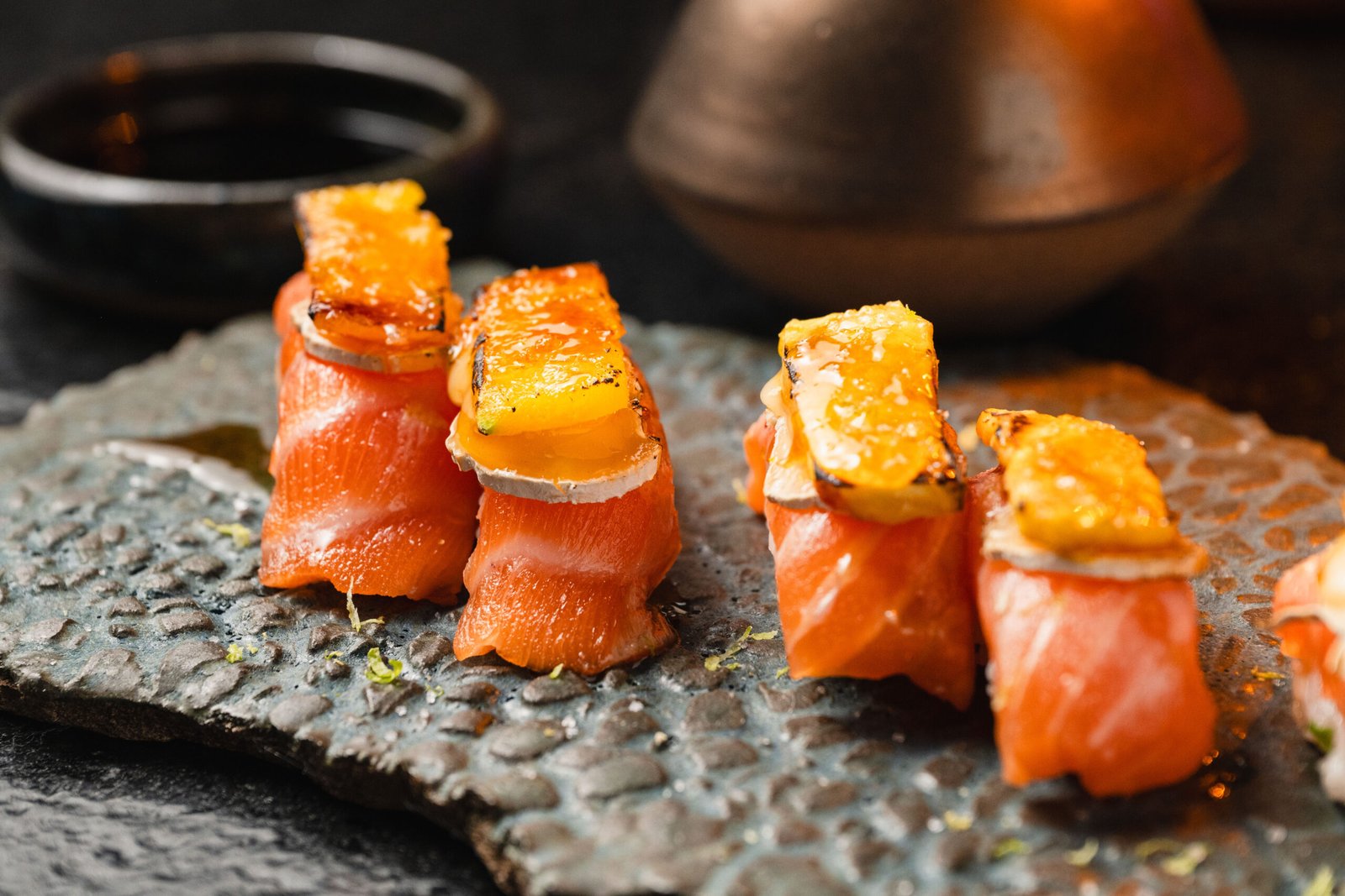 Sushi de salmão em peças altas com finalização dourada no Yokocho Izakaya