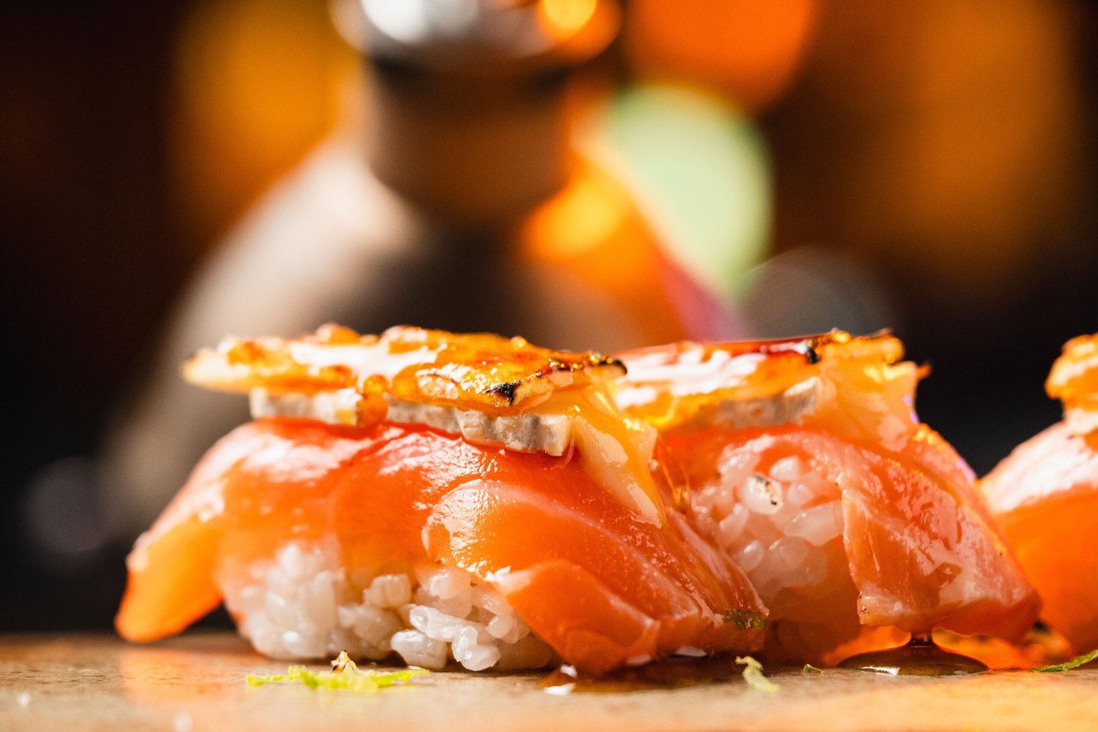 Finalização de prato sob a luz ambiente do Yokocho Izakaya