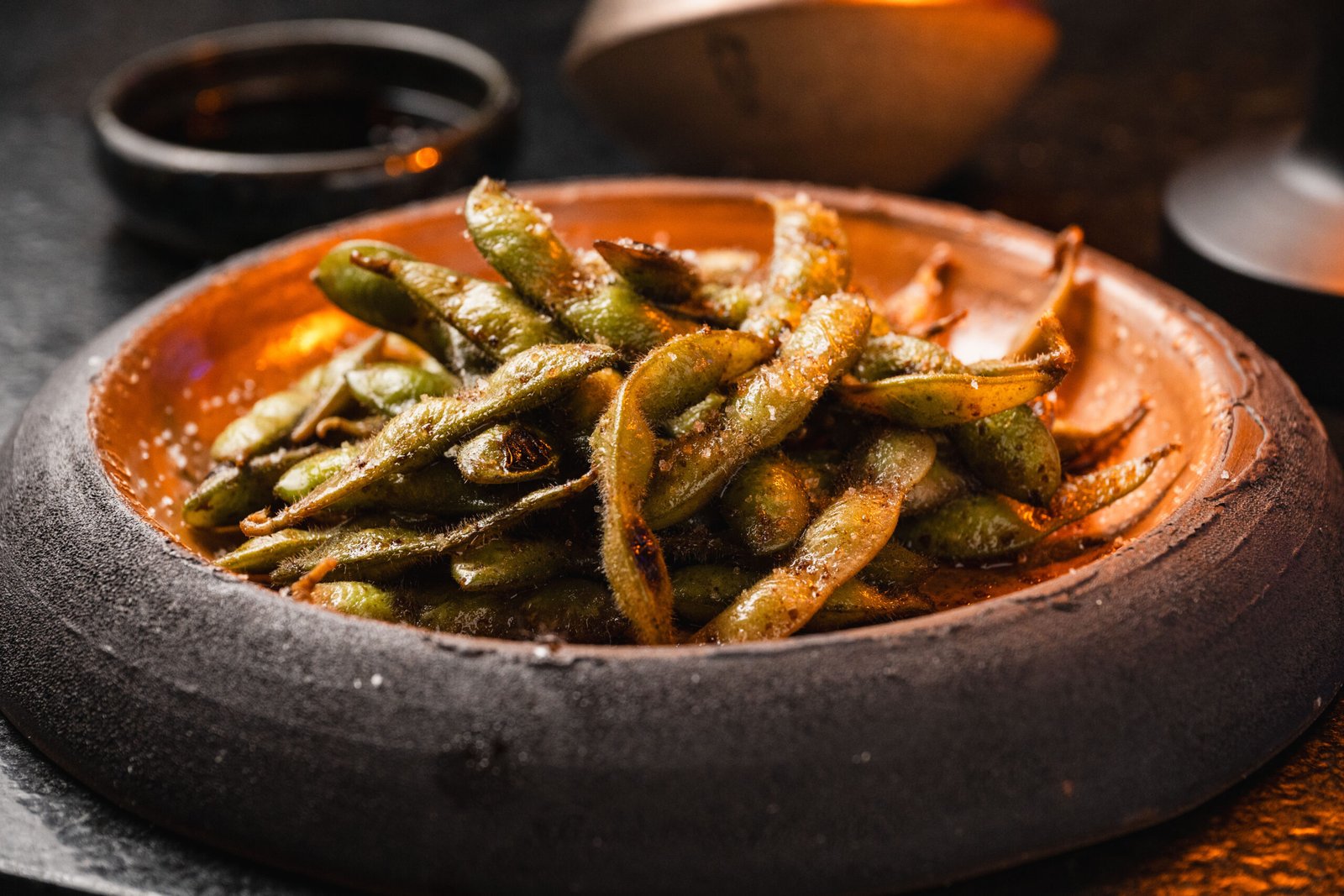 Edamame temperado em prato artesanal no Yokocho Izakaya
